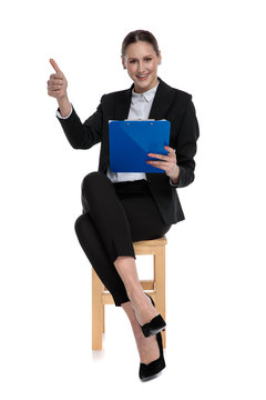 businesswoman holding clipboard and making ok sign