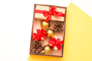 Christmas decorations for the home in a wooden tray on a background of white and yellow flowers. Space for your text.