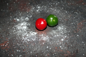 round green and red peppers on a dark kitchen table
