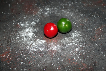 round green and red peppers on a dark kitchen table