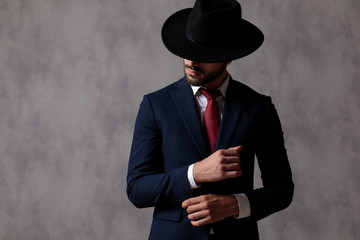 Attractive businessman adjusting his sleeve and looking to the side