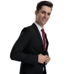 Happy businessman unbuttoning his jacket and looking away