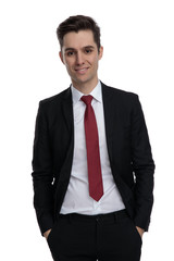 Charming businessman holding both hands in his pockets