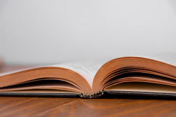Old open book on a wooden table. White background. Copy space