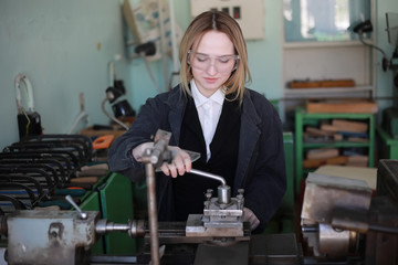 Young woman engineer working at machine tool