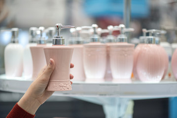 Woman buying a new liquid soap jar on a store counter abstract background.