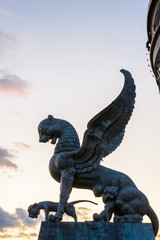 Fototapeta premium The sculpture female of winged snow leopard (Ak Bars, Aq Bars) with cubs, the symbol of Tatarstan near the Kazan wedding palace. Sunset.