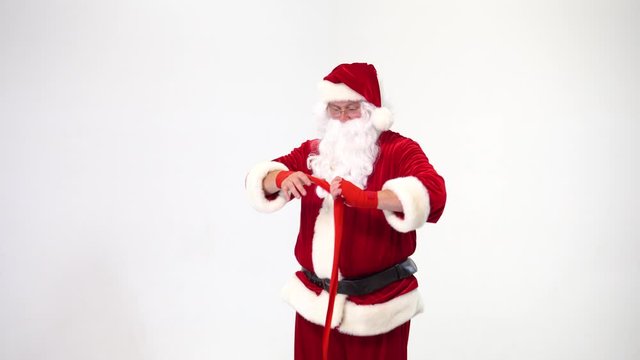 Christmas. Santa Claus on a white background reels up red bandages for bokasa and kickboxing. The image of a fighter.