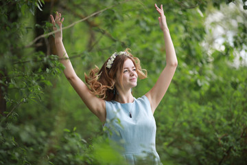 Obraz premium Girl in blue dress in green park