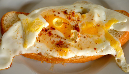 A closeup photo of an egg sandwich with fried eggs and chilly