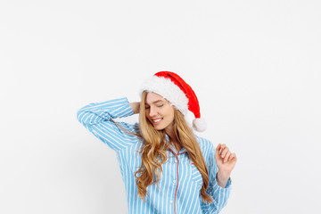 beautiful young girl, in pajamas and Santa Claus hat, on Christmas eve