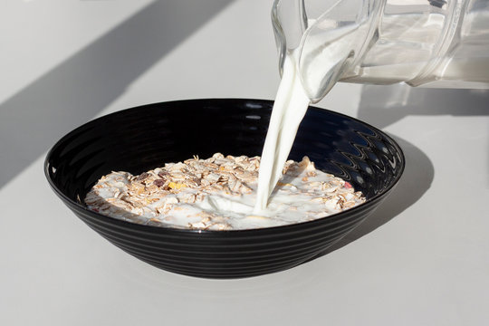 Pouring milk in the dish with muesly