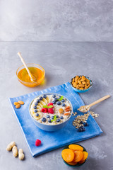 Healthy homemade oatmeal with berries and nuts for breakfast. Oatmeal with fruits, nuts and honey. Oatmeal with blueberries, banana and raspberries