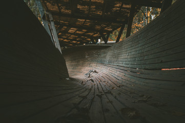 Abandoned luge track in pine woods. Wooden bobsleigh track curves along the trees with vintage luge...