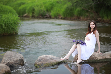 Pregnant woman in nature for a walk in the summer