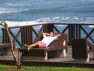 Enjoying life. Young man at the ocean, vacations lifestyle concept.