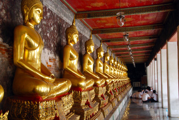 Fototapeta premium row of golden buddhas in temple in Bangkok