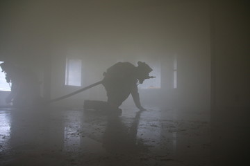 Firefighter crawls through smoke filled house © Kimberly