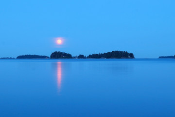 Red sun and reflection in the water in Helsinki, Finland