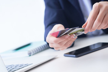 Businesswoman with many different credit cards in hands close-up. Cashless payments, anti-fraud and financial security, entering client discount program number, filling personal information concept.
