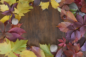 Naklejka na ściany i meble Autumn leaf on wood black background top view orange leaf on old grunge wood deck, copy place for inscription, tablet for text.