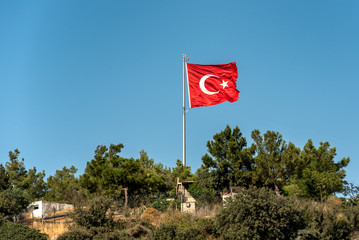 National flag of Turkey on top of the hill against the clear blue sky