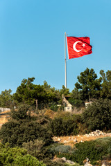 National flag of Turkey on top of the hill against the clear blue sky