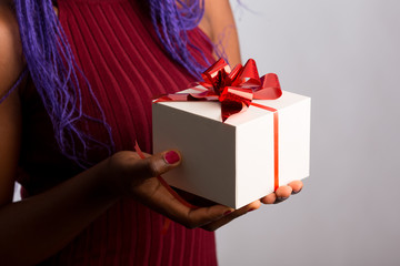Close up view of hands are giving a beautiful gift box to you, female giving gift, presents and greeting season concept
