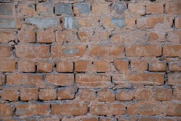 Texture of brick wall with peeling orange-and-gray paint