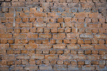Texture of brick wall with peeling orange-and-gray paint