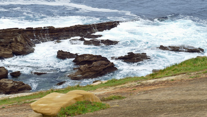 Coast of the sea with waves crashing on the rocks. Mount with boils and limestone.