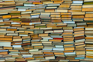 A huge amount of stacked old books. Wall of books.