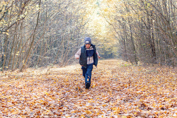 Little boy running in the woods