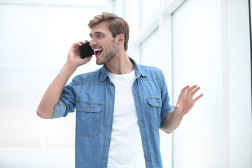 young man talking on the phone standing in office