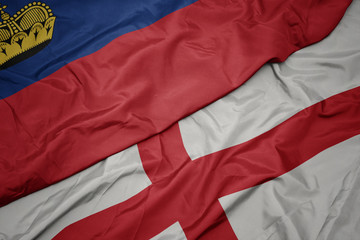 Fototapeta premium waving colorful flag of england and national flag of liechtenstein.