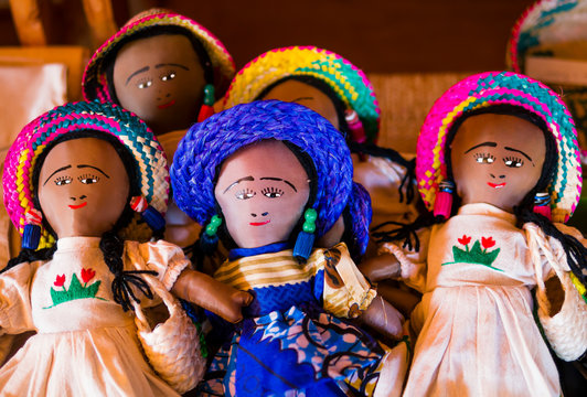 Row of rag dolls wearing traditional clothes and colorful straw hats, Madagascar