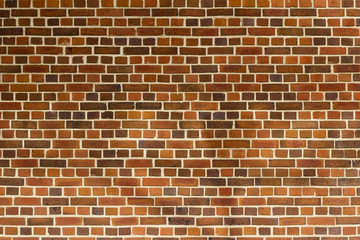 Reddish brown color vintage brick wall texture with a quilted look, showing faint shadows of a tree and street lamp