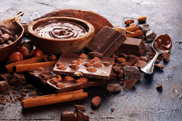 Chocolate bar pieces and melting swirl cocoa. Sweet food photo concept. The chunks of broken chocolate on table