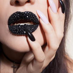 Black lips covered with rhinestones. Beautiful woman with Black lipstick