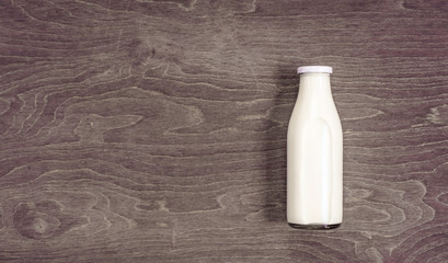 Milk bottle on wooden table with copy space