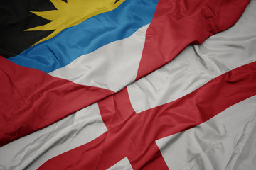 waving colorful flag of england and national flag of antigua and barbuda.