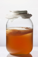 Glass jar of Kombucha fermented tea .