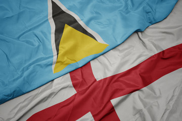 waving colorful flag of england and national flag of saint lucia.