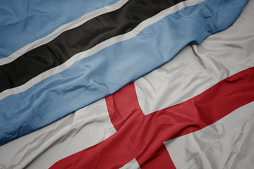 waving colorful flag of england and national flag of botswana.