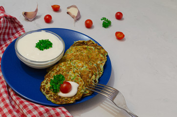 Vegetable cutlets from zucchini with garlic, Cherry tomatoes and yogurt sauce. Top view.