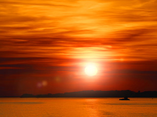 Colorful amazing red sunset. Natural sunset, bright sky, water surface, sun glare