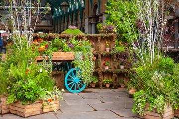 Fototapeta na wymiar London, UK. Covent Garden Market. Flowers and plants on wagon display. Tourist landmark in centre of London.