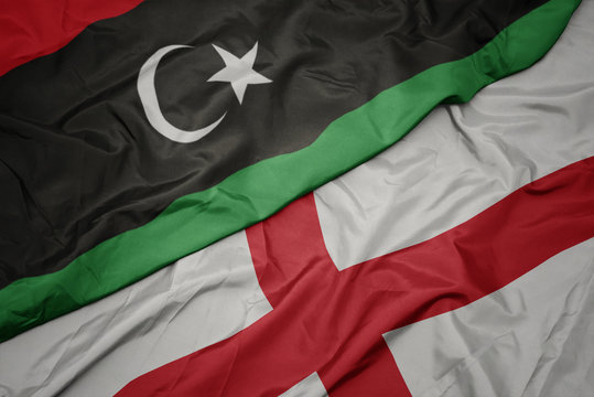 waving colorful flag of england and national flag of libya.