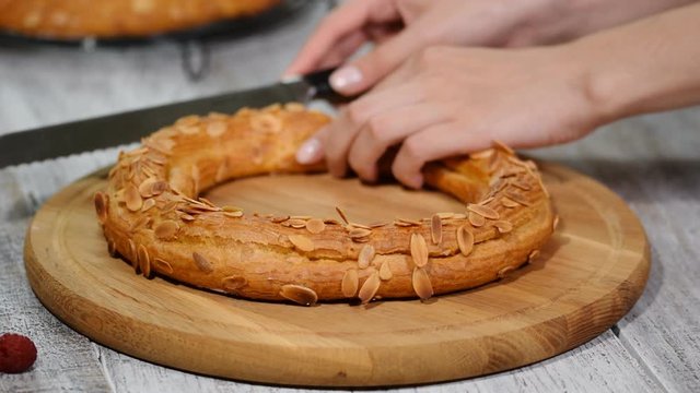 Confectioner woman makes Paris Brest in the kitchen. Choux pastry eclair cake Paris Brest. Series
