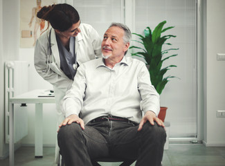 Female doctor talking to a patient on a wheelchair